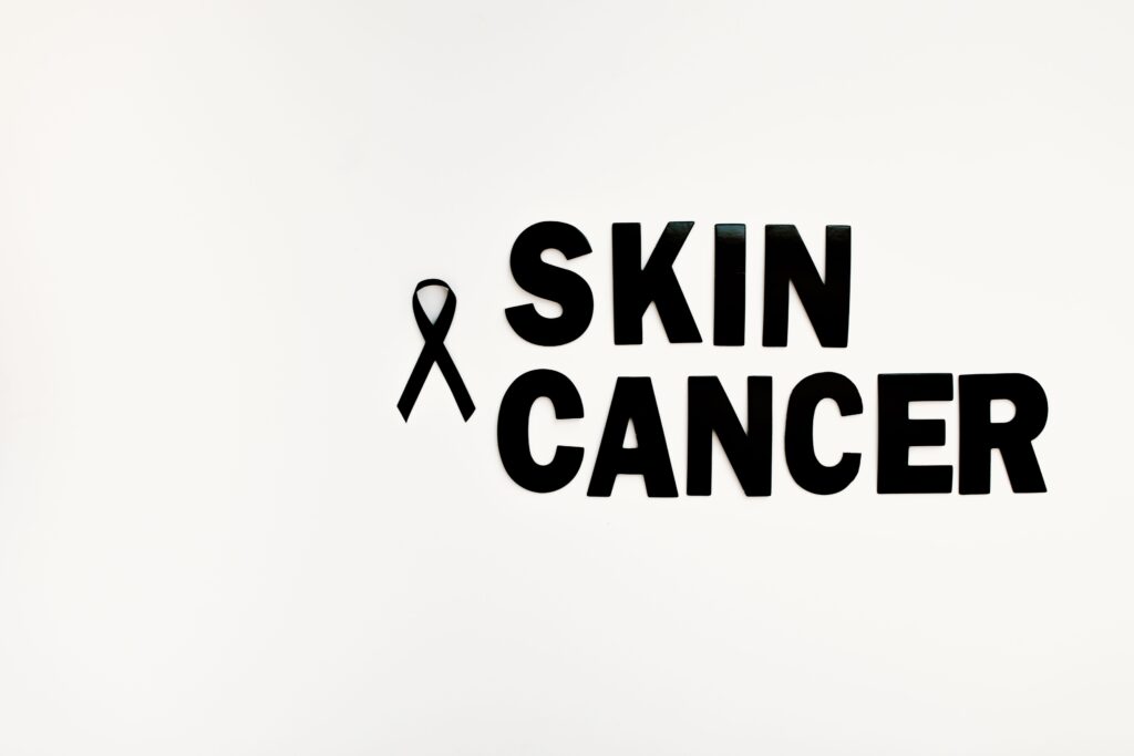 Black ribbon and text highlighting skin cancer awareness on a white background.